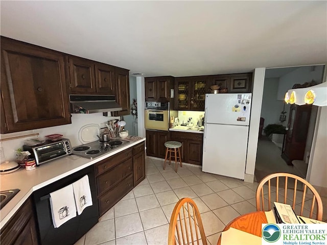 4941 Glenview St, North Whitehall Twp, PA 18078 - kitchen featuring white appliances, under cabinet range hood, light countertops, dark brown cabinetry, and light tile patterned flooring