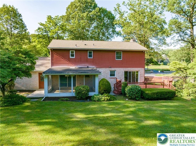 4015 Sycamore Dr, Lehigh Twp, PA 18067 - back of property with a chimney, brick siding, a deck, and a yard