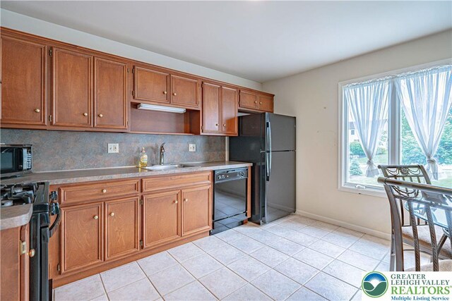 26 Chestnut Commons Ct, Easton, PA 18040 - kitchen featuring black appliances, decorative backsplash, brown cabinetry, light tile patterned flooring, and light countertops