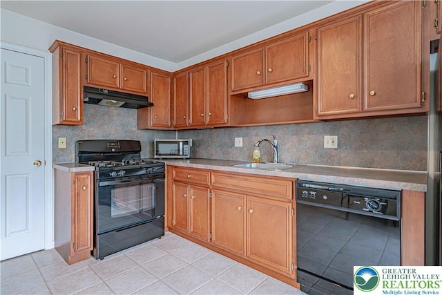 26 Chestnut Commons Ct, Easton, PA 18040 - kitchen with black appliances, under cabinet range hood, light tile patterned floors, and brown cabinets