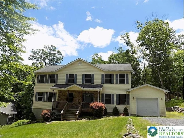 217 St Andrews Dr, Middle Smithfield Twp, PA 18324 - colonial home featuring covered porch, an attached garage, an outdoor structure, driveway, and a front yard