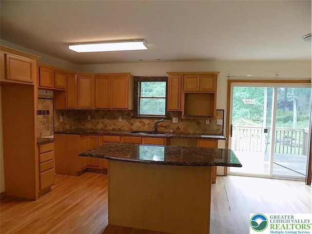 217 St Andrews Dr, Middle Smithfield Twp, PA 18324 - kitchen featuring light wood-style floors, a center island, decorative backsplash, and dark stone counters
