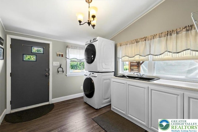 320 Nulton Ave, Palmer Twp, PA 18045 - washroom with stacked washing machine and dryer, a chandelier, dark wood-style flooring, cabinet space, and crown molding