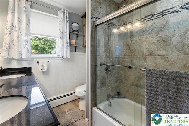 320 Nulton Ave, Palmer Twp, PA 18045 - full bathroom featuring baseboard heating, shower / bath combination with glass door, a wainscoted wall, wood finished floors, and double vanity