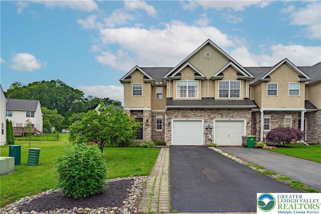 301 Maple Ct, Alburtis Boro, PA 18011 - view of front facade featuring stucco siding, asphalt driveway, stone siding, a front yard, and an attached garage