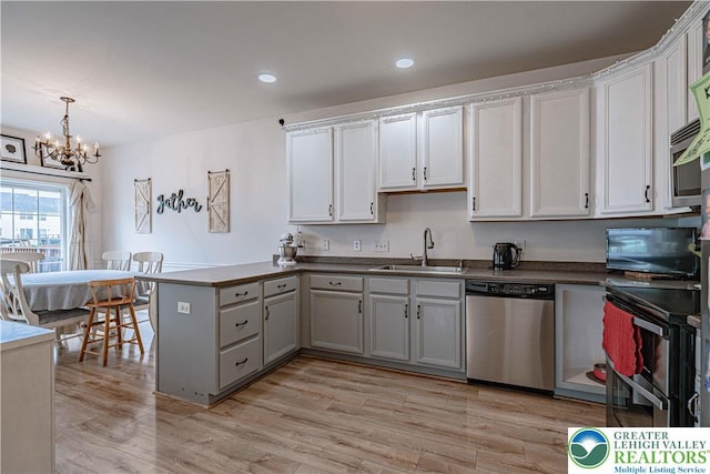 301 Maple Ct, Alburtis Boro, PA 18011 - kitchen featuring stainless steel appliances, a peninsula, a chandelier, light wood finished floors, and dark countertops