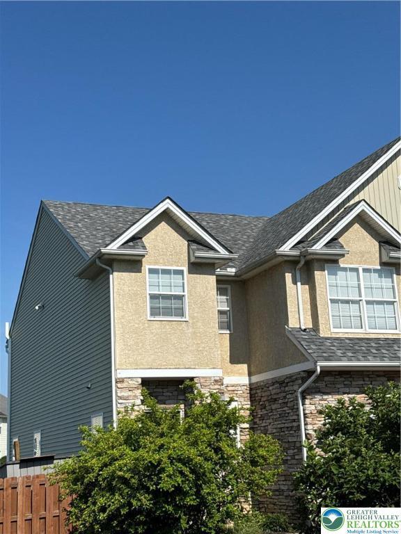 301 Maple Ct, Alburtis Boro, PA 18011 - view of side of home with stone siding, a shingled roof, and stucco siding