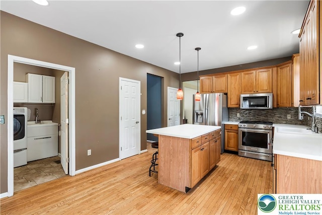 2535 Clark Pl, Forks Twp, PA 18040 - kitchen featuring stainless steel appliances, light wood finished floors, decorative backsplash, a center island, and light countertops