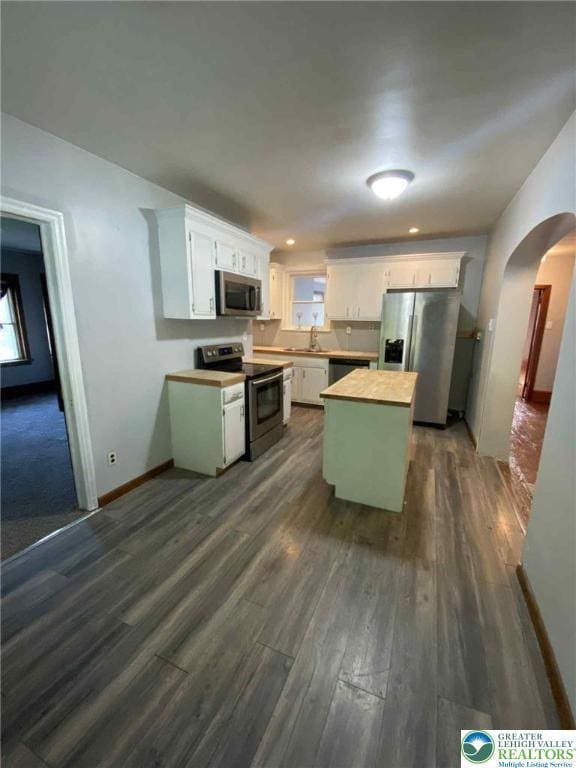 1027 Clamtown Rd, West Penn Twp, PA 18252 - kitchen with stainless steel appliances, dark wood-type flooring, arched walkways, white cabinetry, and recessed lighting