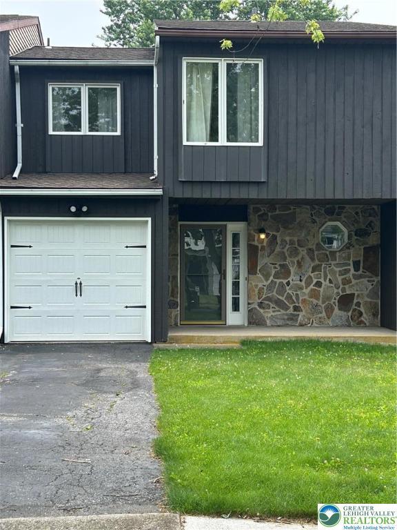 349 Tamarack Dr, South Whitehall Twp, PA 18104 - multi unit property with stone siding, a garage, a front yard, and asphalt driveway