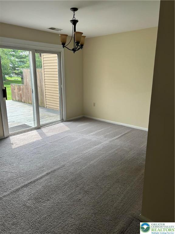 349 Tamarack Dr, South Whitehall Twp, PA 18104 - spare room featuring carpet and a chandelier
