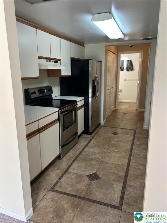 349 Tamarack Dr, South Whitehall Twp, PA 18104 - kitchen featuring stainless steel appliances, under cabinet range hood, white cabinetry, and inlaid floor details
