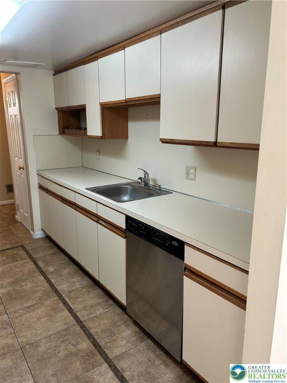 349 Tamarack Dr, South Whitehall Twp, PA 18104 - kitchen featuring dishwasher, white cabinetry, light countertops, and inlaid floor details