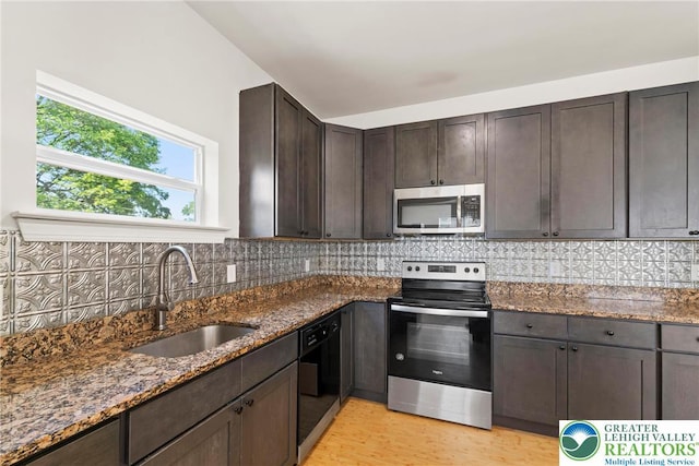 271 W Fairview St W, Bethlehem City, PA 18018 - kitchen featuring appliances with stainless steel finishes, light wood-style floors, dark stone counters, dark brown cabinetry, and decorative backsplash