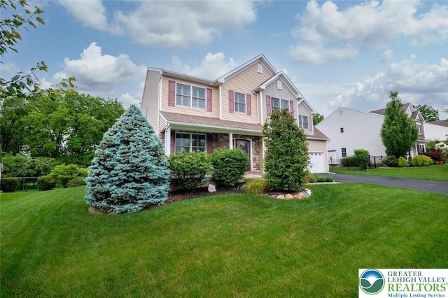 2186 Eagles Landing Dr, Upper Nazareth Twp, PA 18064 - view of front of home featuring a garage, a front lawn, driveway, and stone siding