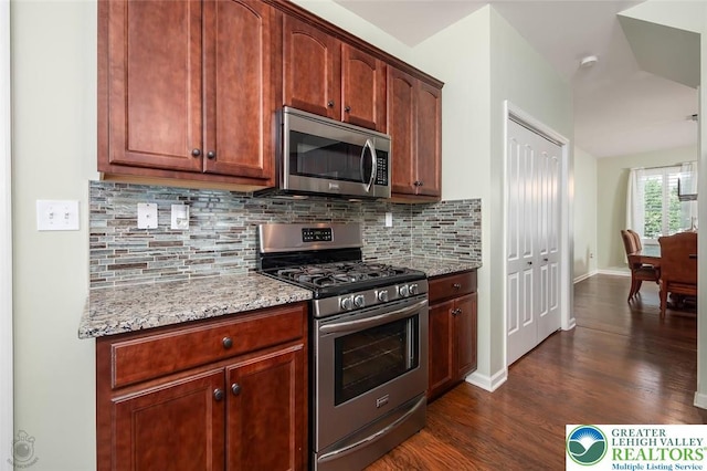2186 Eagles Landing Dr, Upper Nazareth Twp, PA 18064 - kitchen featuring appliances with stainless steel finishes, decorative backsplash, dark wood-type flooring, and light stone countertops