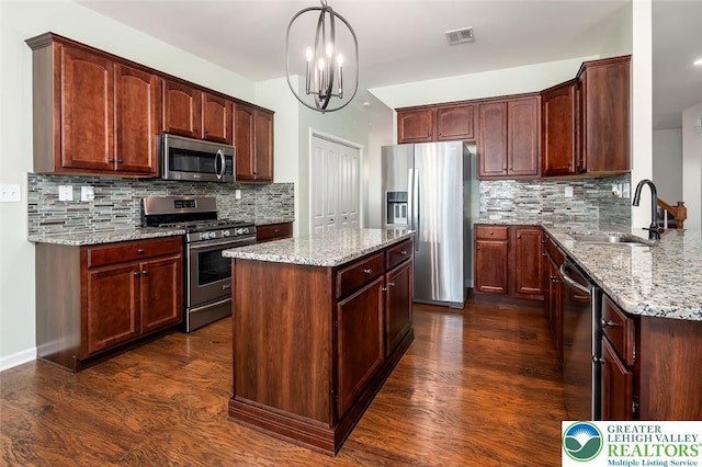 2186 Eagles Landing Dr, Upper Nazareth Twp, PA 18064 - kitchen with appliances with stainless steel finishes, light stone countertops, dark wood-type flooring, and backsplash