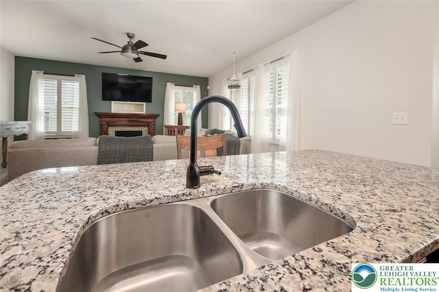 2186 Eagles Landing Dr, Upper Nazareth Twp, PA 18064 - detailed view of a ceiling fan, a fireplace, and light stone counters