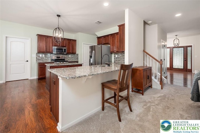 2186 Eagles Landing Dr, Upper Nazareth Twp, PA 18064 - kitchen featuring stainless steel appliances, a peninsula, tasteful backsplash, light stone counters, and recessed lighting