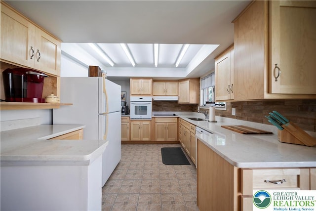 275 E Thomas Ave, Hellertown Boro, PA 18055 - kitchen featuring light brown cabinetry, white oven, backsplash, under cabinet range hood, and a peninsula