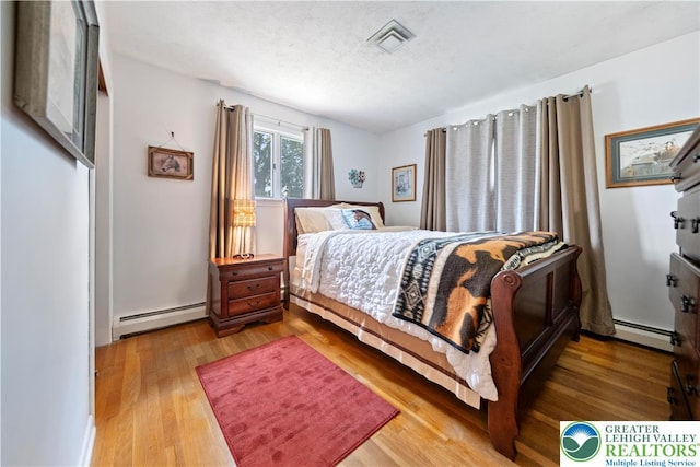 275 E Thomas Ave, Hellertown Boro, PA 18055 - bedroom featuring baseboard heating, wood finished floors, and a textured ceiling