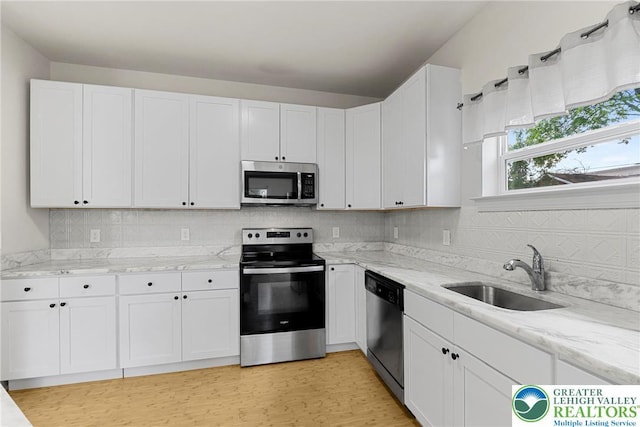 273 W Fairview St W, Bethlehem City, PA 18018 - kitchen with appliances with stainless steel finishes, white cabinets, light stone countertops, and tasteful backsplash
