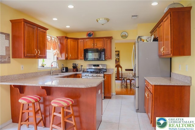 3104 Peacock Dr, Bethlehem Twp, PA 18020 - kitchen featuring appliances with stainless steel finishes, a peninsula, light countertops, a kitchen bar, and recessed lighting