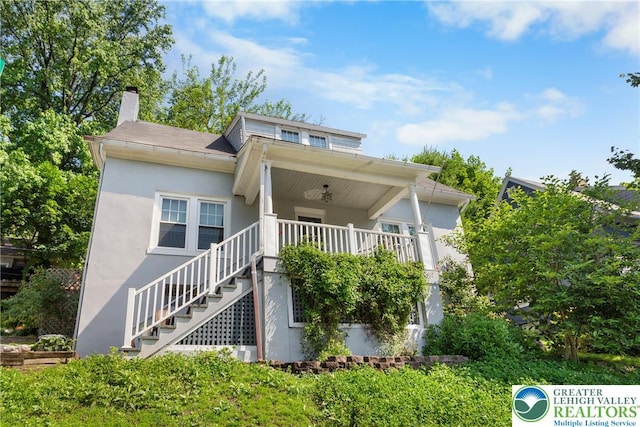 827 Wilbur St, Easton, PA 18042 - view of front of house featuring stucco siding, stairway, and a chimney