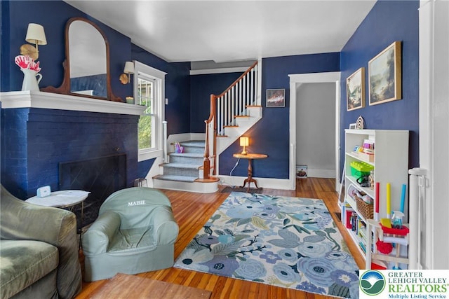 827 Wilbur St, Easton, PA 18042 - living area featuring stairs, wood finished floors, and a brick fireplace