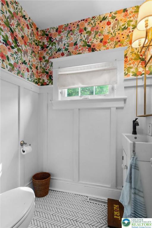 827 Wilbur St, Easton, PA 18042 - half bathroom with wallpapered walls, wainscoting, and a decorative wall