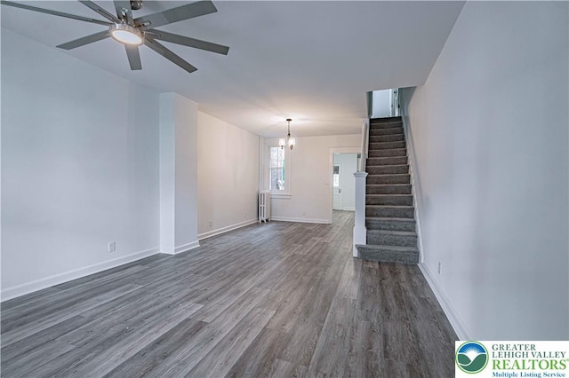 622 N Jefferson St, Allentown City, PA 18102 - unfurnished living room featuring radiator, dark wood-type flooring, a chandelier, stairway, and ceiling fan