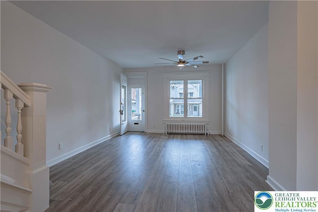 622 N Jefferson St, Allentown City, PA 18102 - unfurnished living room featuring radiator heating unit, dark wood-style floors, a ceiling fan, and stairs