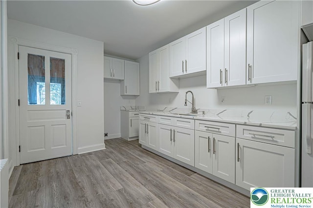 622 N Jefferson St, Allentown City, PA 18102 - kitchen with white cabinetry, light stone countertops, and light wood finished floors