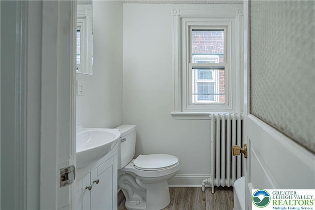 622 N Jefferson St, Allentown City, PA 18102 - bathroom featuring radiator heating unit, vanity, and wood finished floors