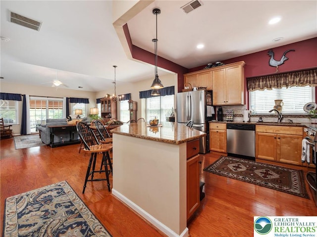 4112 Pine Hurst Dr, Allen Twp, PA 18067 - kitchen with stainless steel appliances, open floor plan, stone countertops, a ceiling fan, and a kitchen island with sink