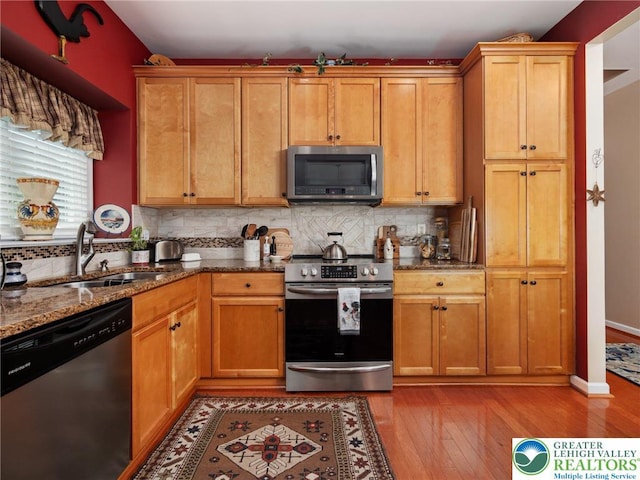 4112 Pine Hurst Dr, Allen Twp, PA 18067 - kitchen with stainless steel appliances, dark stone countertops, light wood-type flooring, and decorative backsplash