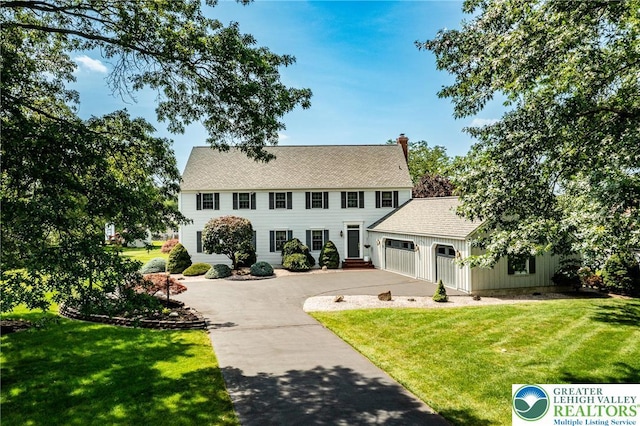 530 Station Rd, Richland Twp, PA 18951 - colonial-style house with concrete driveway, a garage, a front yard, and a chimney