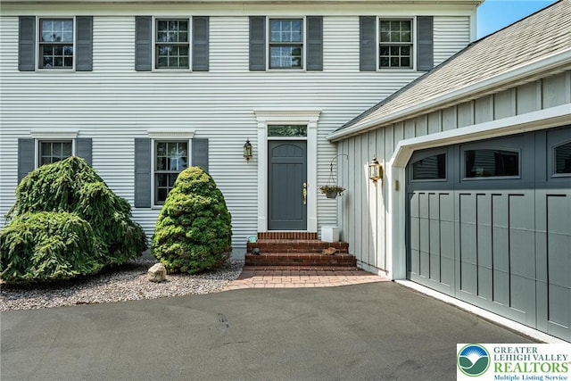 530 Station Rd, Richland Twp, PA 18951 - view of exterior entry with board and batten siding, a garage, and driveway