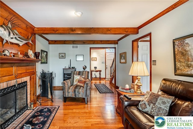 530 Station Rd, Richland Twp, PA 18951 - living room with light wood-type flooring, beam ceiling, stairway, a tile fireplace, and ornamental molding