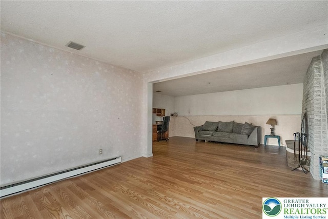 2057 Grove St, South Whitehall Twp, PA 18104 - living area with a baseboard heating unit and wood finished floors