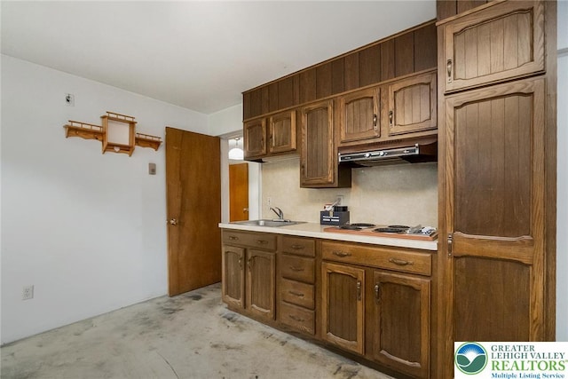 2057 Grove St, South Whitehall Twp, PA 18104 - kitchen with electric cooktop, under cabinet range hood, light countertops, concrete flooring, and brown cabinetry