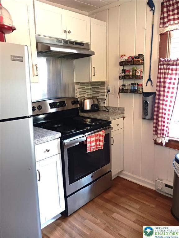 618 Mccabe Ln, Hamilton Twp, PA 18353 - kitchen featuring stainless steel appliances, under cabinet range hood, white cabinets, and wood finished floors