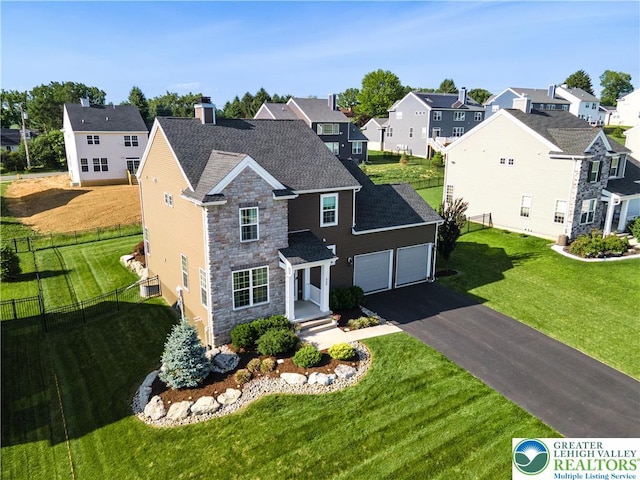 420 Rinaldi Ln, Forks Twp, PA 18040 - traditional home with stone siding, a residential view, asphalt driveway, and a garage