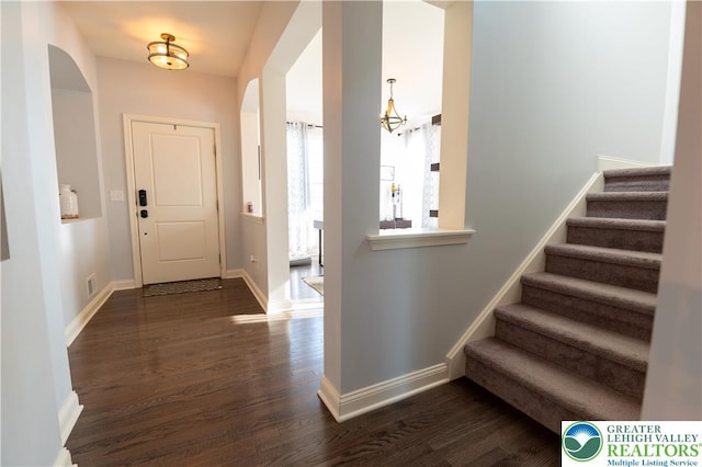 420 Rinaldi Ln, Forks Twp, PA 18040 - foyer entrance with arched walkways, dark wood-type flooring, stairs, and a chandelier