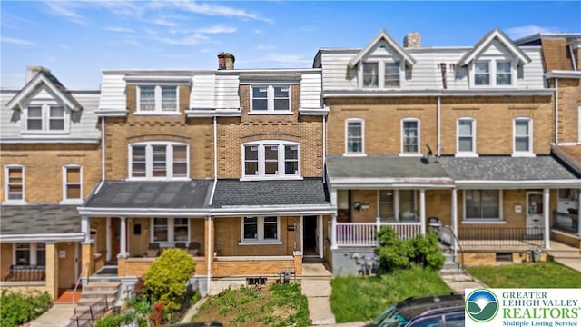 907 N 5th St, Allentown City, PA 18102 - townhome / multi-family property featuring a porch, brick siding, and a chimney