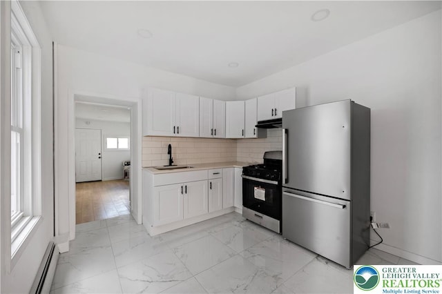 907 N 5th St, Allentown City, PA 18102 - kitchen with appliances with stainless steel finishes, baseboard heating, light countertops, backsplash, and white cabinetry