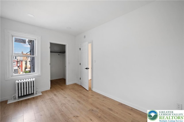 907 N 5th St, Allentown City, PA 18102 - unfurnished bedroom featuring radiator, light wood finished floors, and a spacious closet