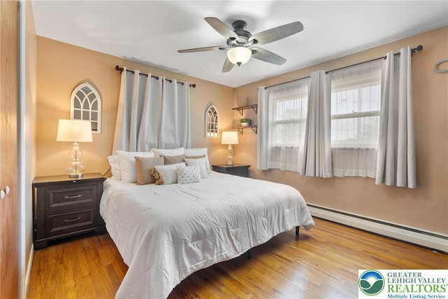 2213 W Woodlawn St, South Whitehall Twp, PA 18104 - bedroom featuring a baseboard heating unit, wood finished floors, and a ceiling fan