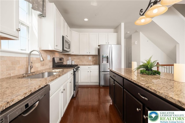 4618 Woodbrush Way, Upper Macungie Twp, PA 18104 - kitchen with appliances with stainless steel finishes, white cabinetry, dark wood-style floors, light stone counters, and backsplash