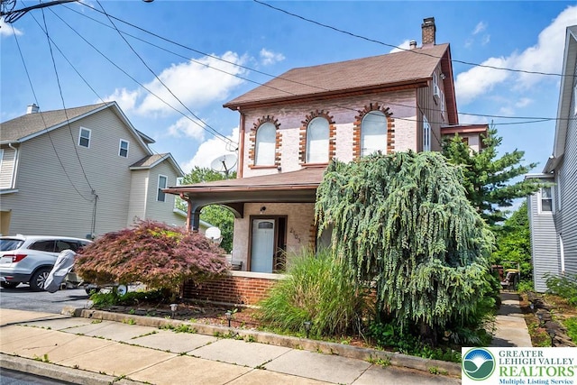 2103 N 1st Ave, Whitehall Twp, PA 18052 - view of front of house with brick siding, a porch, a chimney, and roof with shingles